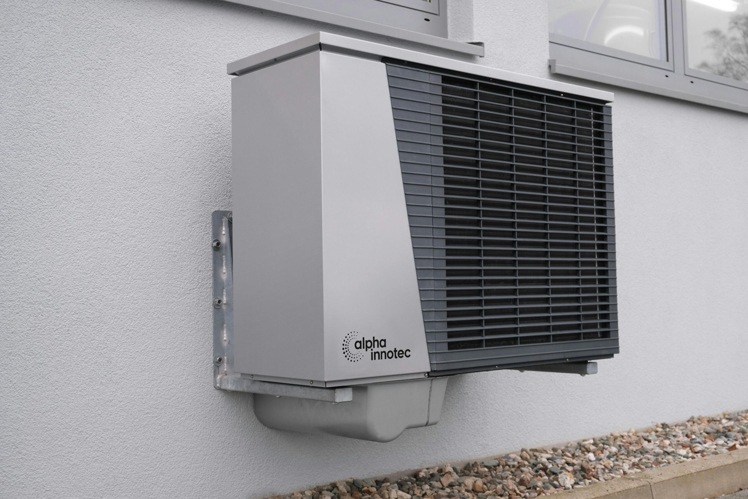 Heat Pumps Vs Gas Boilers Outdoor air conditioning unit mounted on a residential building exterior.