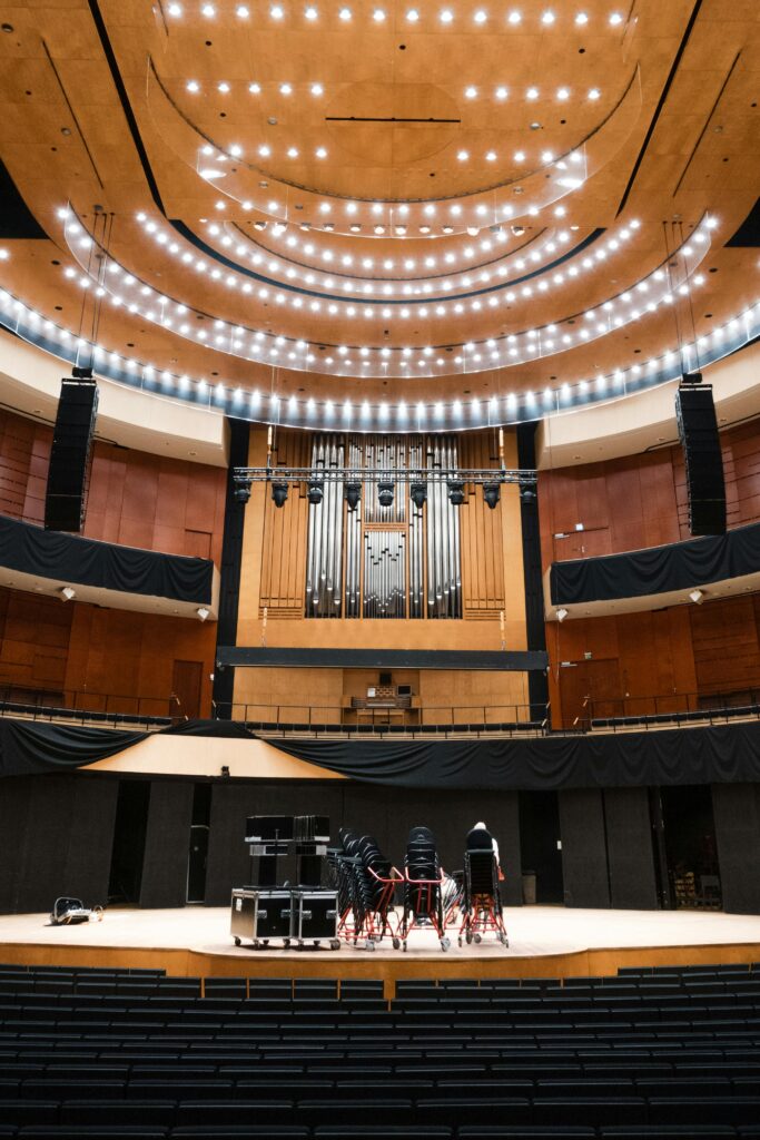 Interior view of a modern concert hall featuring a grand organ on stage.