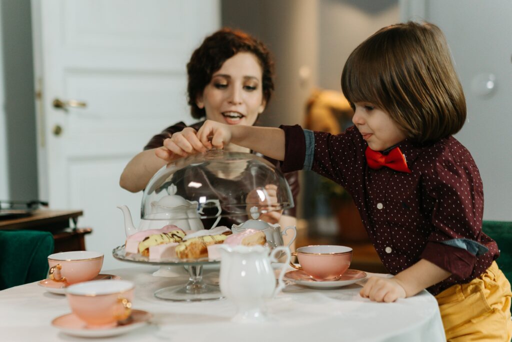 pexels-photo-6970518-6970518 A mother and child sharing tea and pastries at an indoor table, enhancing family moments.